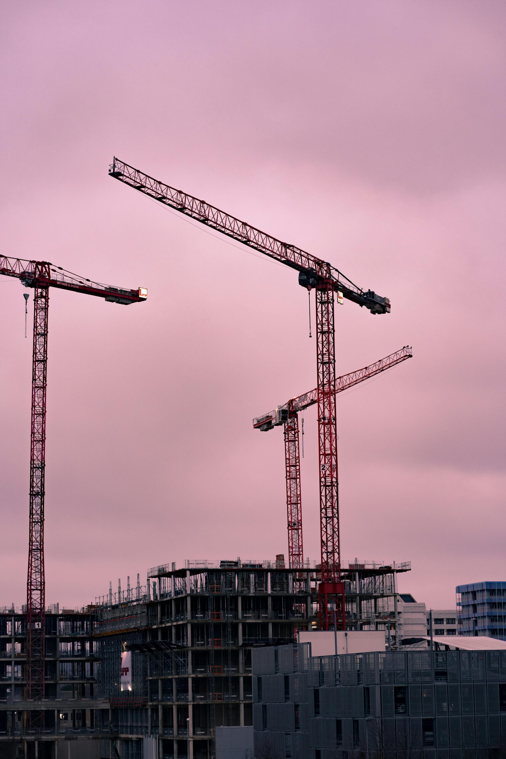Tower cranes dominate the skyline at a construction site in Koblenz, Germany.