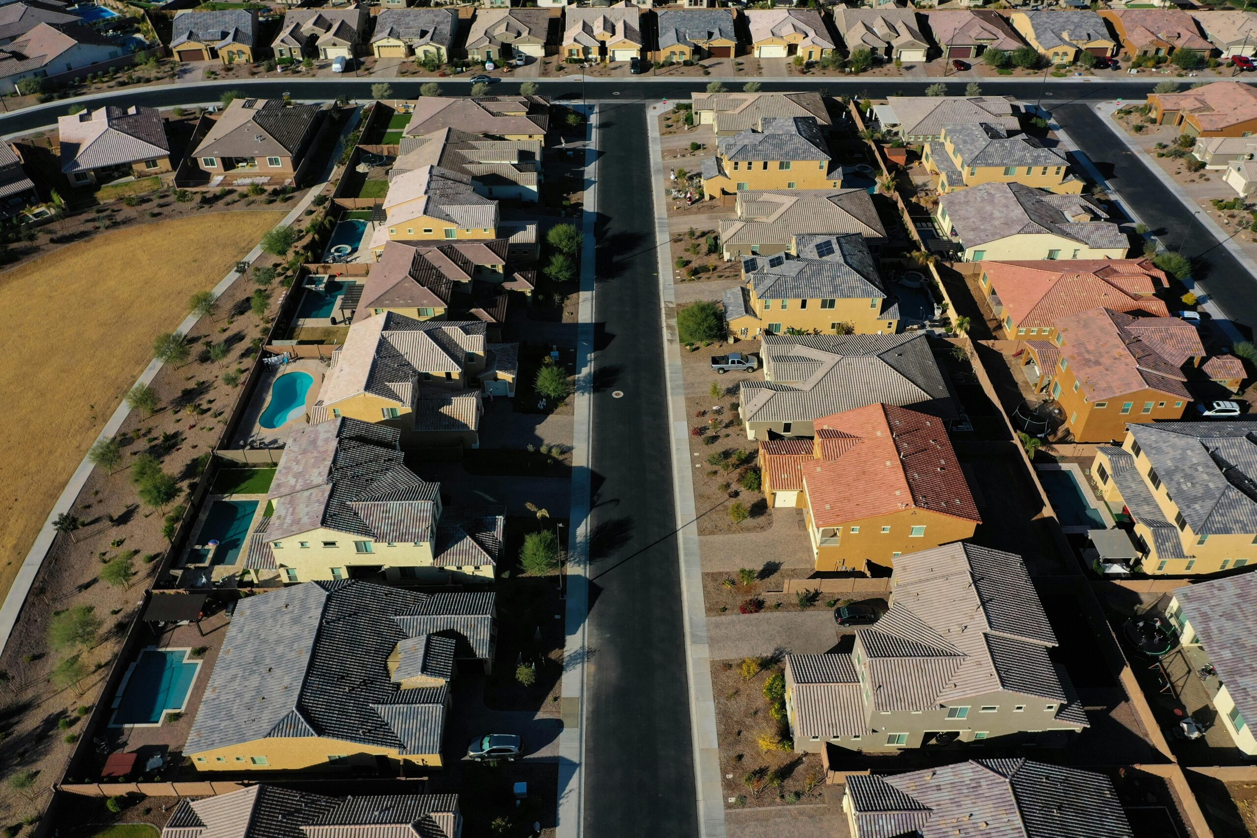 Aerial shot of a suburban residential area with neatly arranged houses and streets.