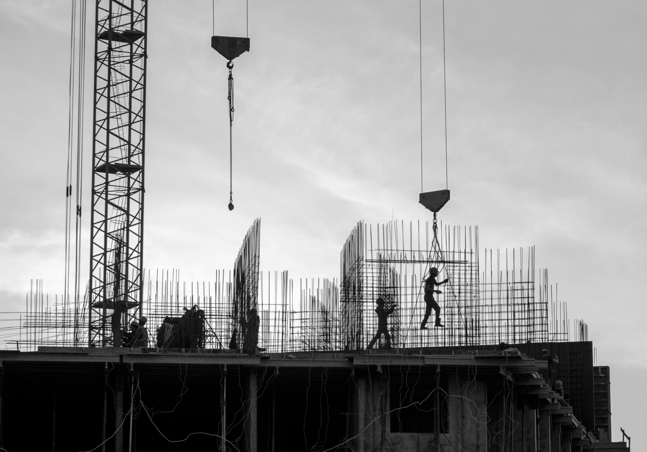 Silhouette of workers on a construction site with cranes and scaffolding in Saint Petersburg.